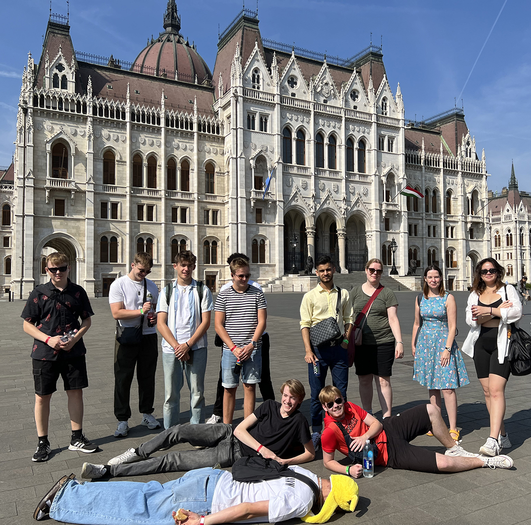 En gruppe elever fra Slotshaven Gymnasium poserer for kameraret foran en flot arkitektonisk bygning.